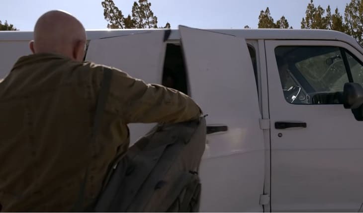 Mike gets inside the side of van with Gus sitting in passenger seat