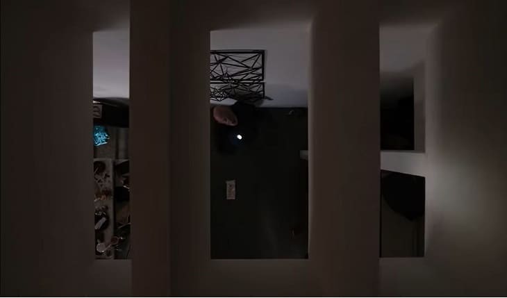 Mike uses flashlight to look up at ceiling