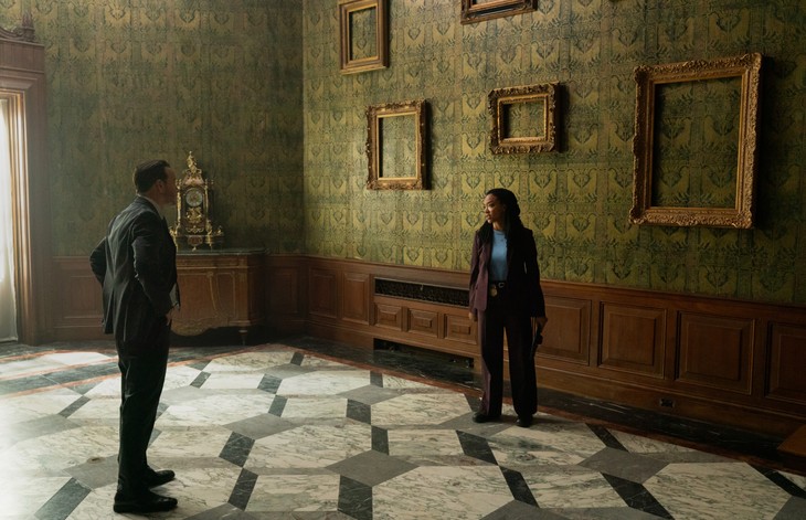 Wide shot with empty gold frames on green wallpaper